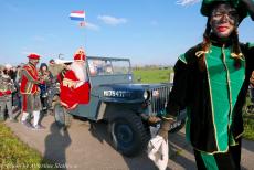 Intocht van Sinterklaas - Intocht van Sinterklaas in een Ford GPW Jeep uit 1942, november 2022: Sinterklaas rijdt in een Jeep uit de Tweede Wereldoorlog, omringd door...